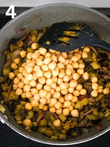 chickpeas added to aubergine curry in large frying pan