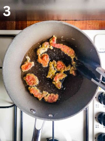 person shallow frying crispy shredded beef in vegetable oil in a large fryng pan
