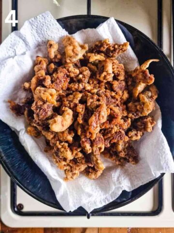 batch of crispy fried beef in a bowl lined with kitchen paper