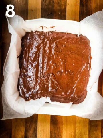 lined 8x8" square baking pan full of chocolate brownie batter before baking