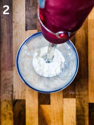 person blending cottage cheese until smooth with a stick blender
