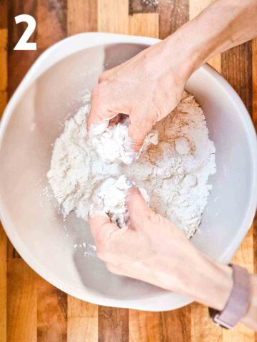 person rubbing cold butter into flour with their fingertips for making homemade scones