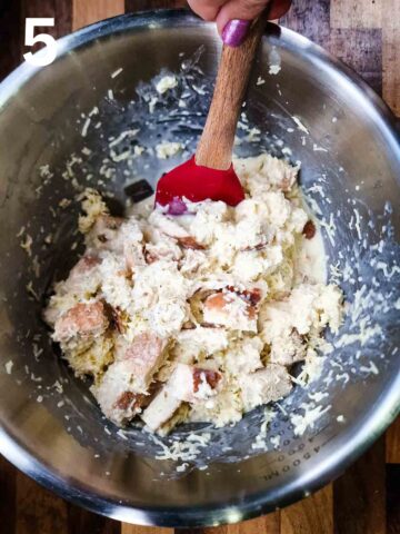 person mixing cheese egg custard mixture with stale diced bread