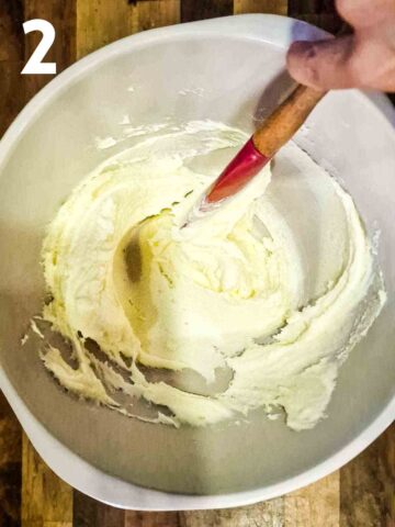 person creaming butter and sugar together in large mixing bowl by hand