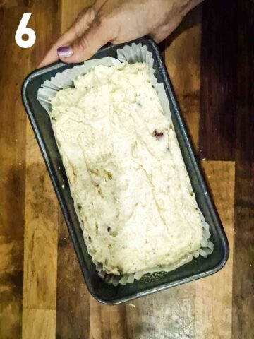 2lb 900g lined loaf tin full of cherry cake batter before baking in the oven
