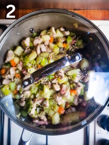 person sauteeing diced mixed vegtables in thyme and butter in a large saucepan covered