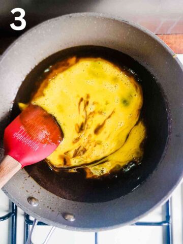 person stirring beaten eggs into cake batter base