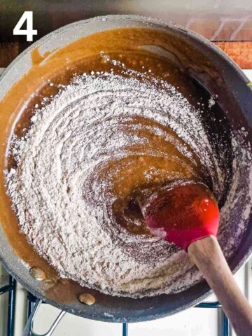 person stirring sifted flour, spices and bicarbonate of soda in a large pan to make Jamaican ginger cake batter
