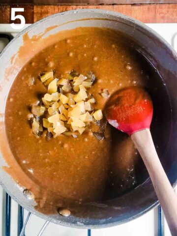 person stirring in diced stem ginger chunks into ginger cake batter