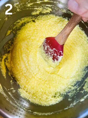 person whisking eggs into creamed butter and sugar in a medium bowl