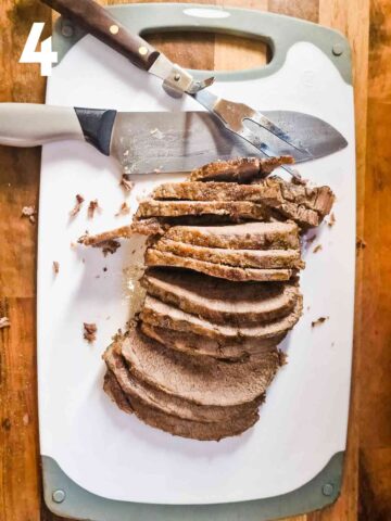 marinated beef brisket sliced with a sharp on chopping board before adding back to the pot with beef gravy