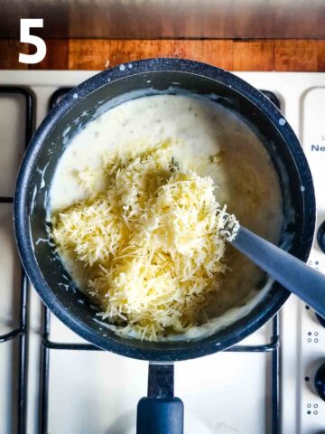 person stirring cheese in thick homemade creamy cheese sauce