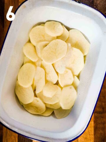 slices of potato n the bottom of a large baking dish