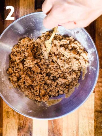 person mixing rhubarb crumble topping into small pebbles with flour, butter, baking powder, cinnamon and brown sugar