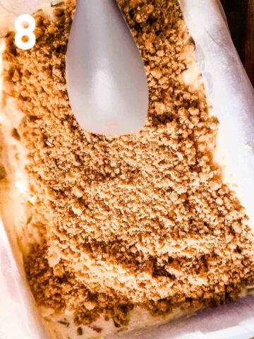 person spreading an even layer of cookie crumble on top a rhubarb cake before baking in the middle of the oven for 50 minutes