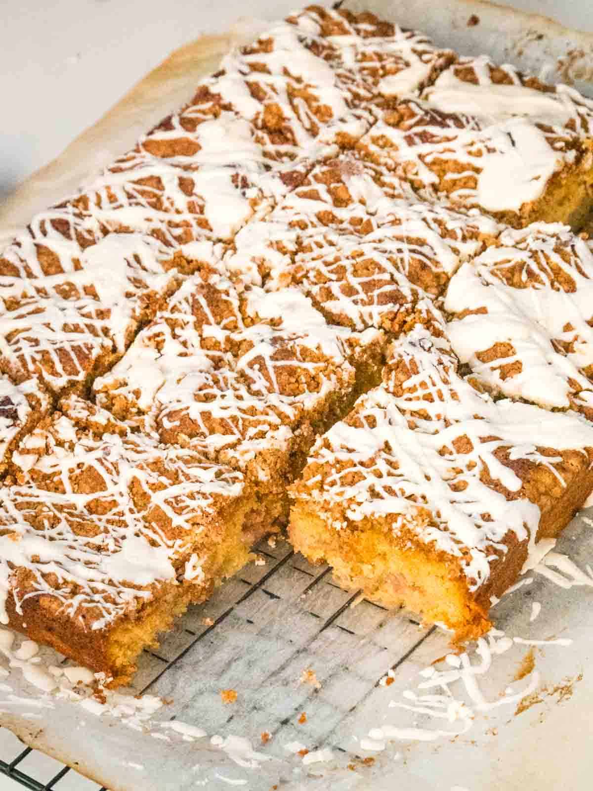 close up of pink rhubarb baked in a crumb traybake on cooling rack
