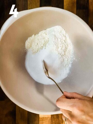 person stirring dry ingredients in a large mixing bowl to make a fruit crumble recipe topping