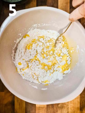 person mixing melted butter into crumbs in a apple and banana crumble topping