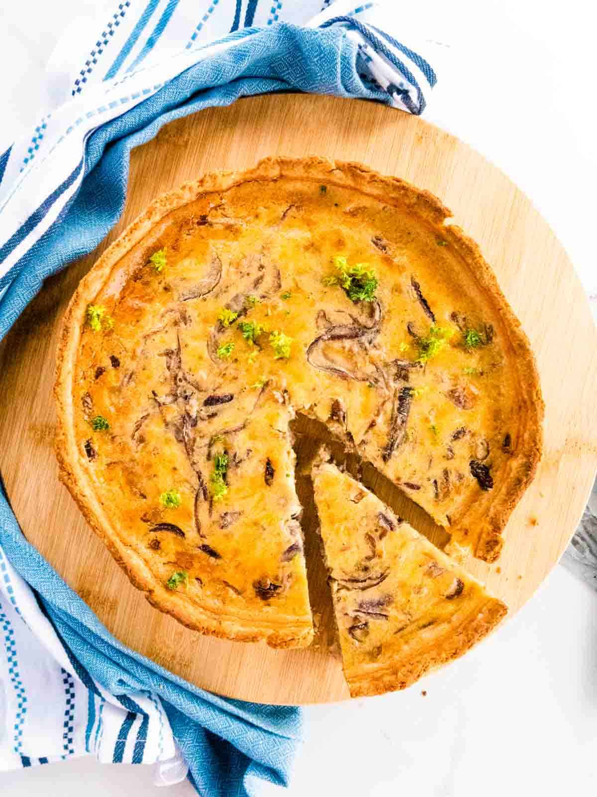 slice of quiche cut from a cheese and caramelised onion homemade quiche with rich shortcrust pastry