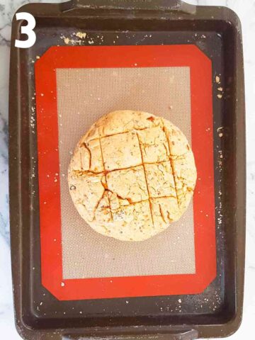 round damper bread cob on a lined baking sheet with silicone mat