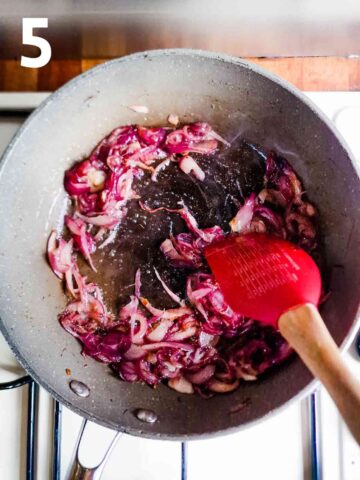 person caramelising red onions in a large frying pan with metled butter and salt