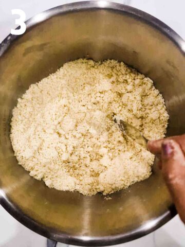 person stirring water into shortcrust dough mixture to start binding it together
