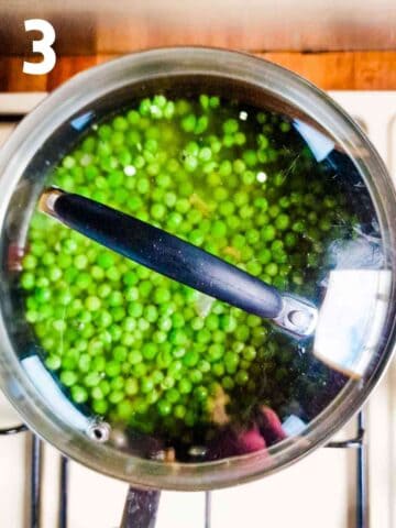 pan covered with fresh peas, onion and garlic to make healthy pea soup in arge pan