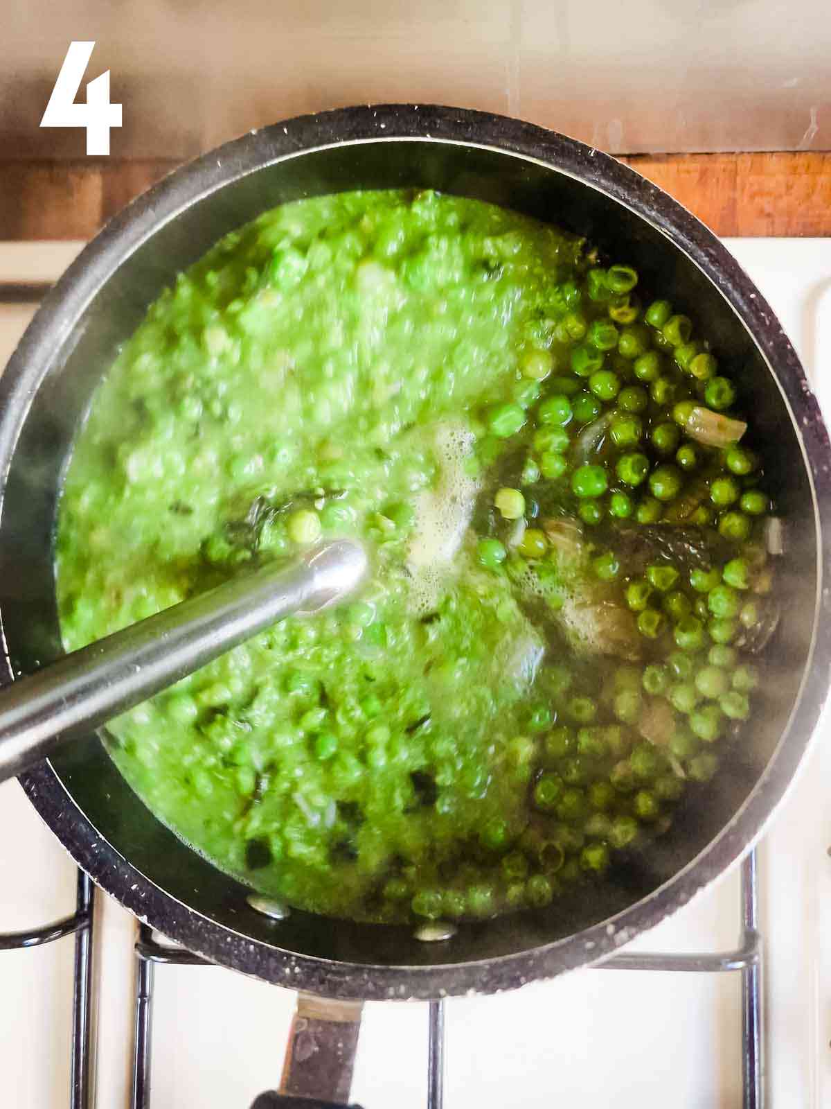 person using a stick blender to puree pea and mint soup