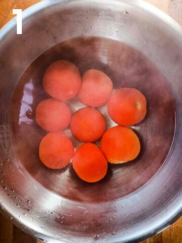 tomatoes in boiling water in a large stainless steel mixing bowl to peel the skins