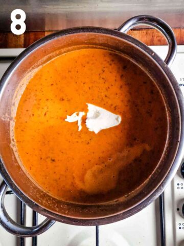 dollop or thick cream in a pot of tomato basil soup