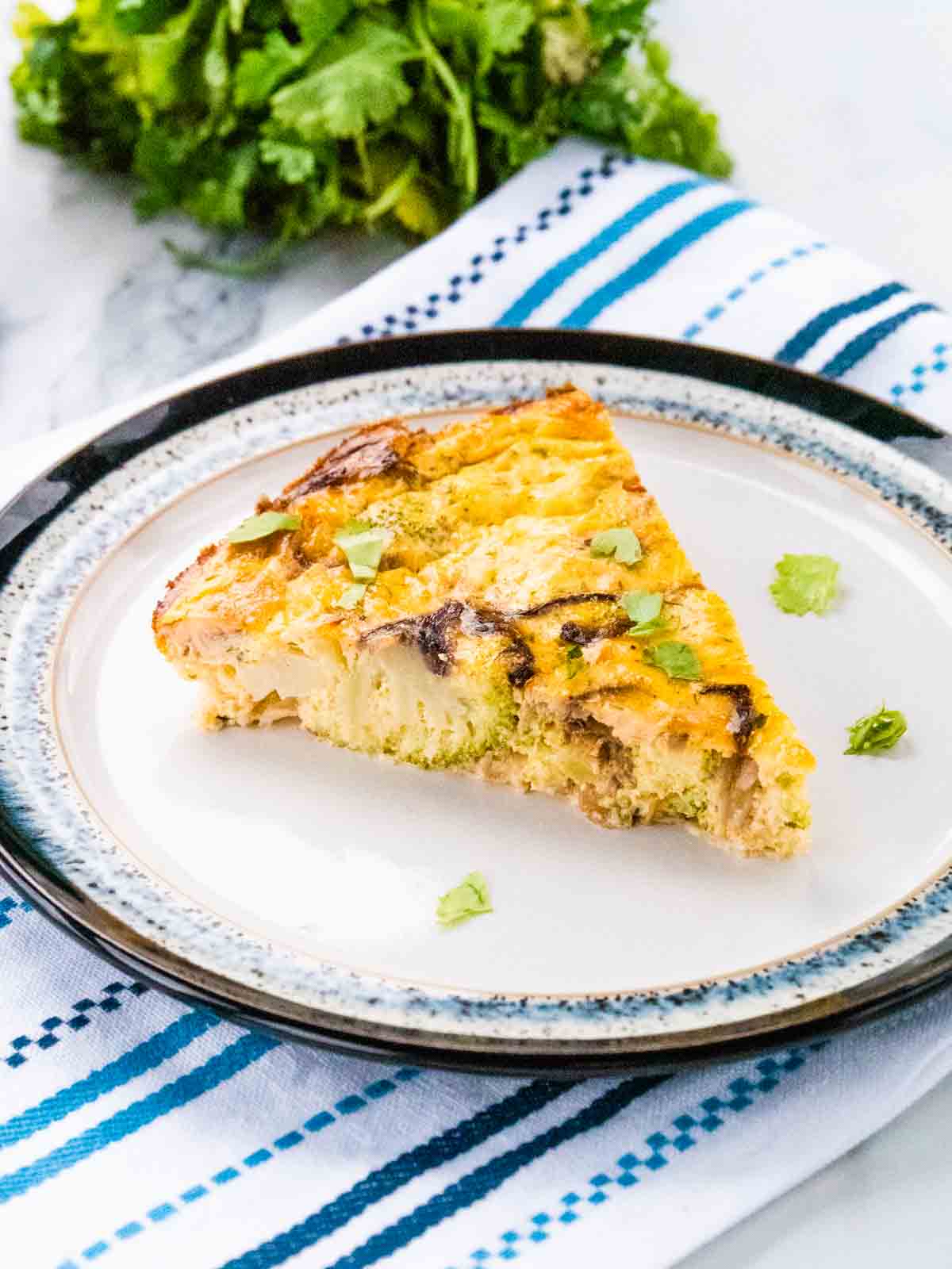close up of a slice of healthy no pastry unofficial Slimming World salmon and broccoli quiche on a plate
