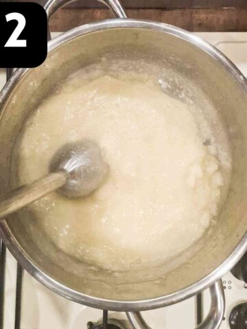 person pureeing apples with a stick blender