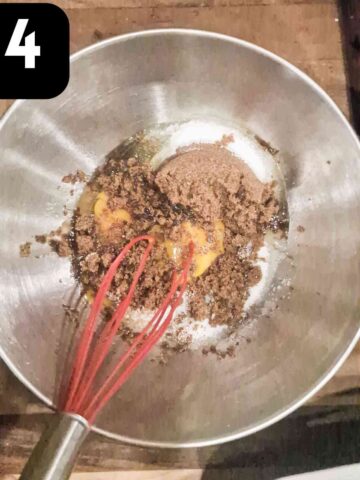 person whisking eggs, soft light brown sugar and cinnamon in a mixing bowl