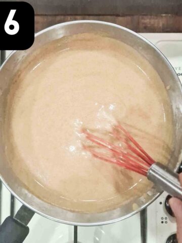 person whisking apple curd constantly while cooking on a low heat until thickened