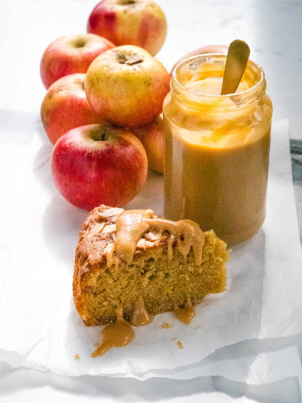slice of sponge cake with apples on a piece of parchment paper served with apple curd drizzle on top