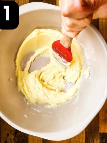 person creaming softened butter and sugar in a large mixing bowl