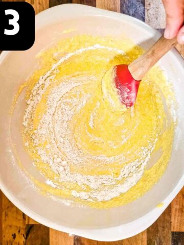 person stirring in self raising flour to make apple cake batter
