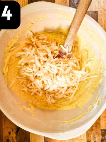 person folding in grated apples into sponge cake batter
