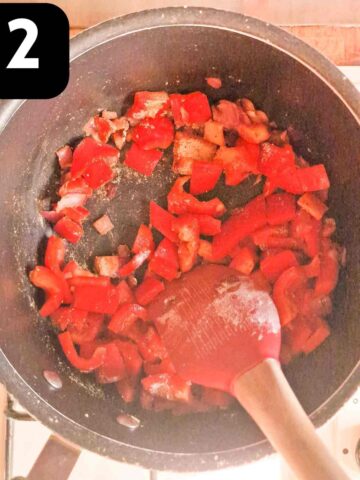 diced red peppers frying in large saucepan with onions