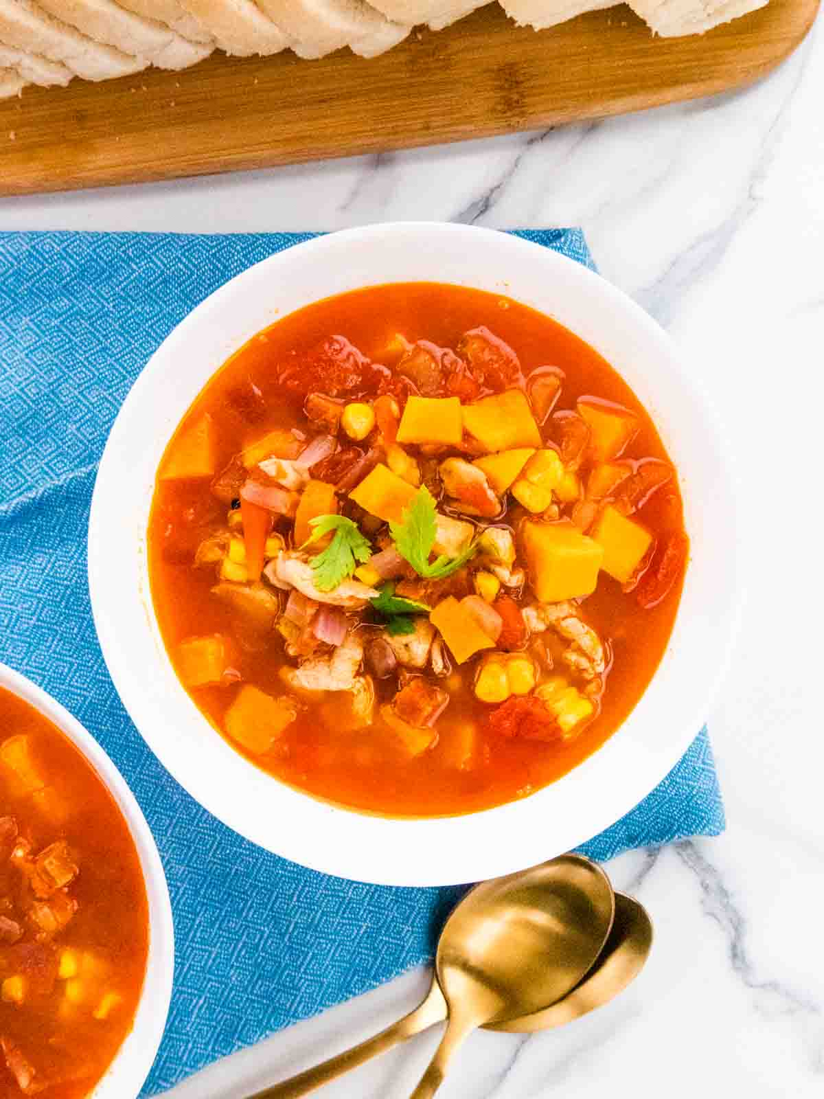 close up of large white bowl with diced vegetables for a chicken chorizo Mediterranean soup