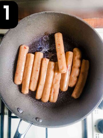 chilli chicken sausages being seared in a large frying pan