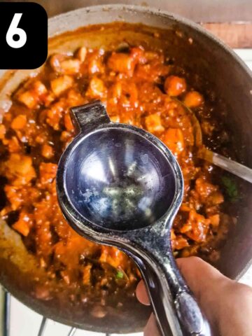 person squeezing lemon juice into pan of gumbo