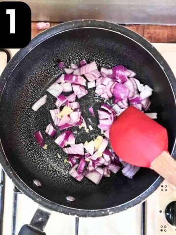 person sauteing onions and garlic in a large non stick frying pan