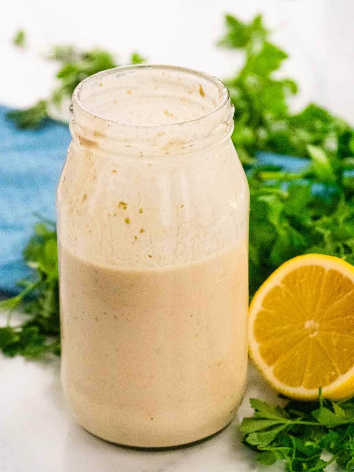 close up of creamed tuna mayonnaise sauce in a jar with lemon