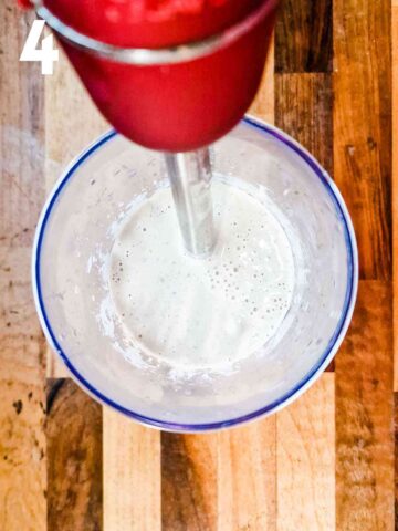 person blending vitel toné sauce with an immersion blender