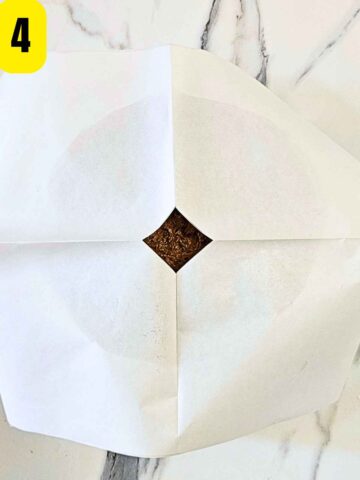 Step 4: Cover the cake tin with baking paper with a small vent cut in the centre.
